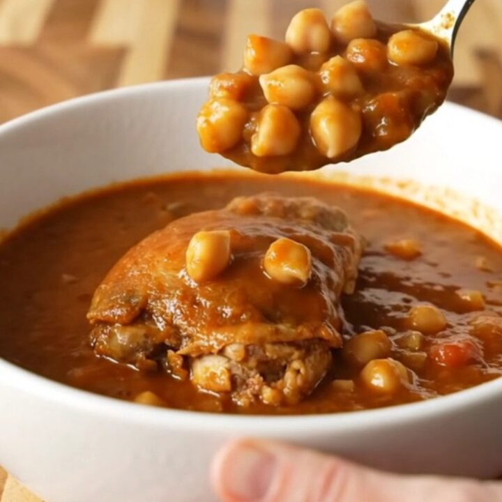 A bowl of smoky chicken and chickpea stew with tender chicken pieces and chickpeas in a vibrant tomato sauce.
