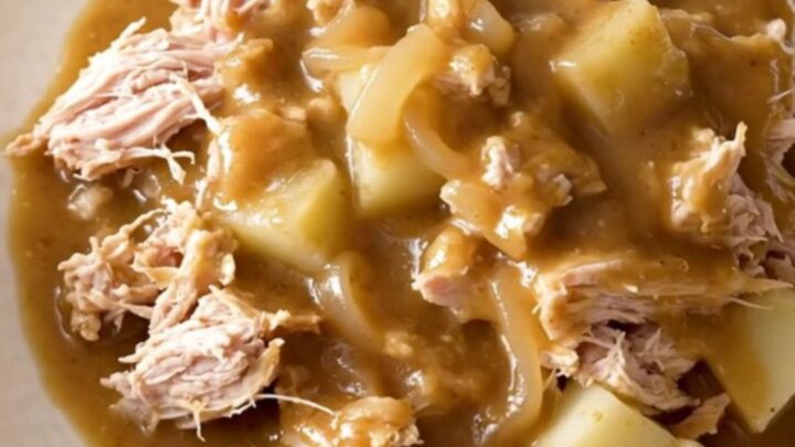 A close-up of a slow cooker filled with ground turkey, potatoes, and savory onion gravy.