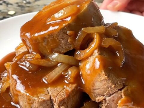 Succulent honey BBQ pork tenderloin medallions glazed in a thick, shiny sauce on a white plate.