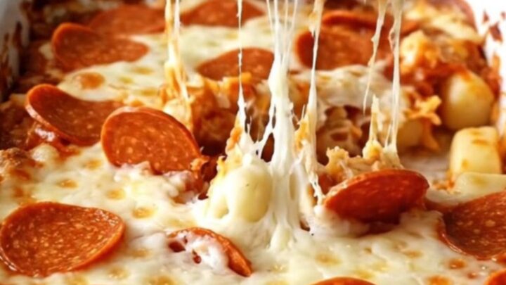A top-down view of a rectangular white baking dish filled with potato gnocchi, pizza sauce, mozzarella, and pepperoni.