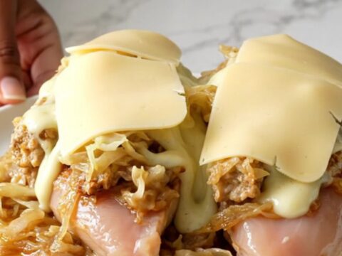 Slow cooker chicken breasts topped with sauerkraut, Thousand Island dressing, and melted Swiss cheese.