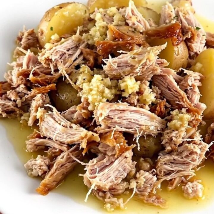 A close-up of slow-cooked ground turkey and baby potatoes in a garlic butter sauce, served on a white plate.