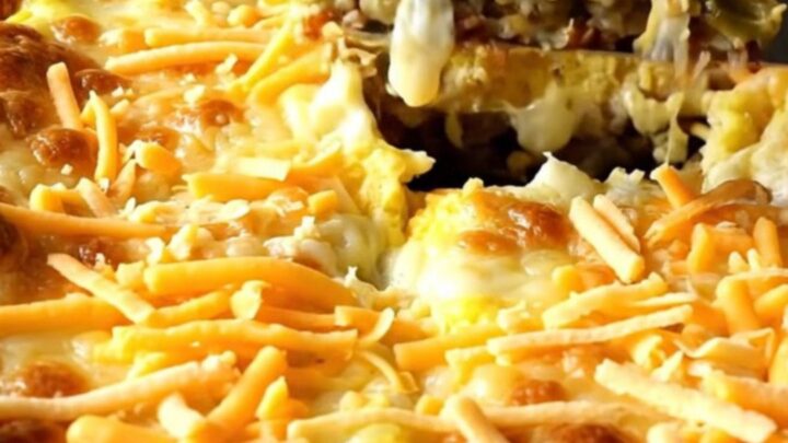 A golden, puffed Chile Relleno Egg Casserole in a white ceramic dish.
