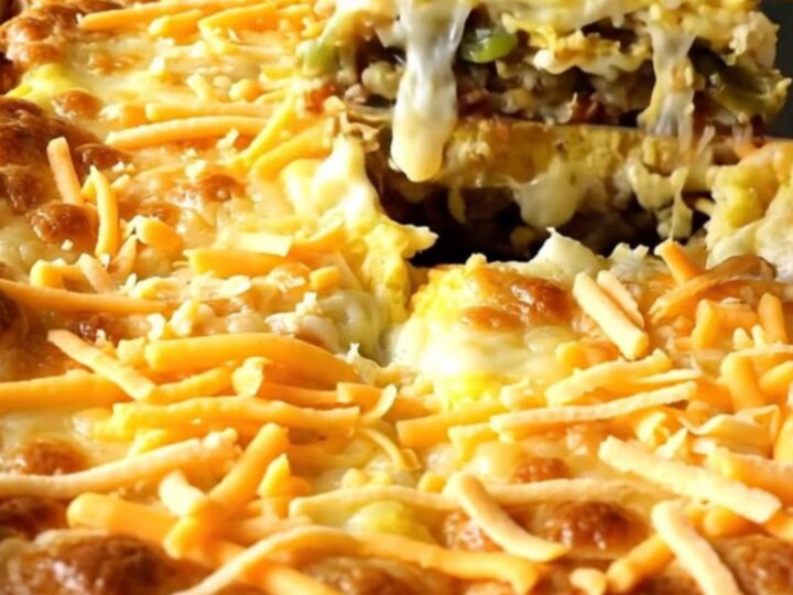 A golden, puffed Chile Relleno Egg Casserole in a white ceramic dish.