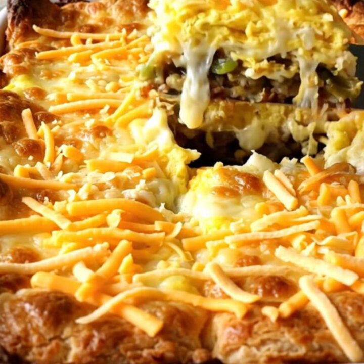 A golden, puffed Chile Relleno Egg Casserole in a white ceramic dish.