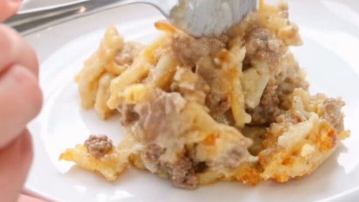 A warm, creamy Amish beef and hashbrown casserole in a glass dish with steam rising.