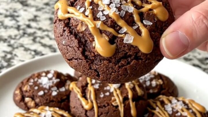A plate of chocolate peanut butter oat no-bake cookies with a sea salt garnish.