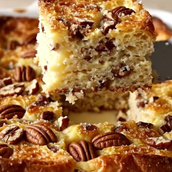A golden, puffed Maple Pecan French Toast Bake in a white rectangular dish on a beige countertop.