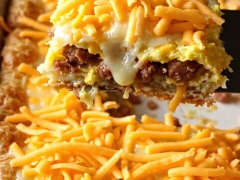 A golden-brown sausage, egg, and cheese breakfast bake in a rectangular ceramic dish.