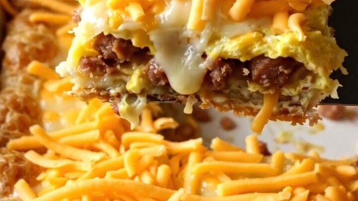 A golden-brown sausage, egg, and cheese breakfast bake in a rectangular ceramic dish.