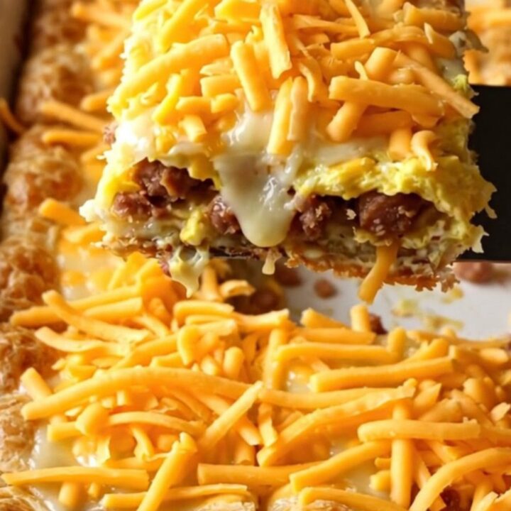 A golden-brown sausage, egg, and cheese breakfast bake in a rectangular ceramic dish.