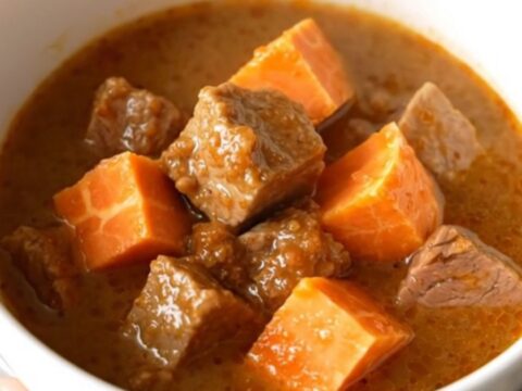 A hearty bowl of smoky pork and sweet potato stew with tender meat and soft vegetables.