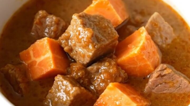 A hearty bowl of smoky pork and sweet potato stew with tender meat and soft vegetables.
