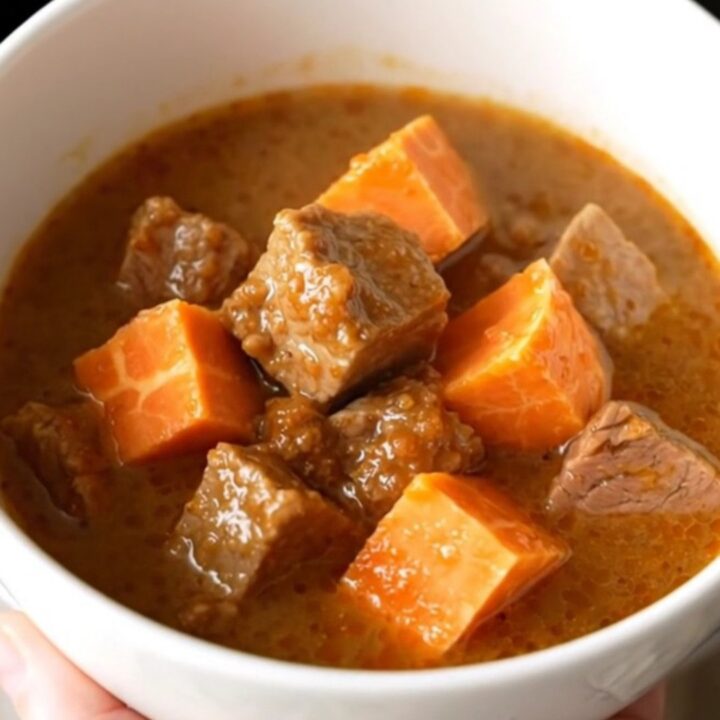 A hearty bowl of smoky pork and sweet potato stew with tender meat and soft vegetables.