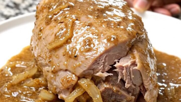 Creamy peppercorn turkey tenderloin in a slow cooker with onions and sauce.
