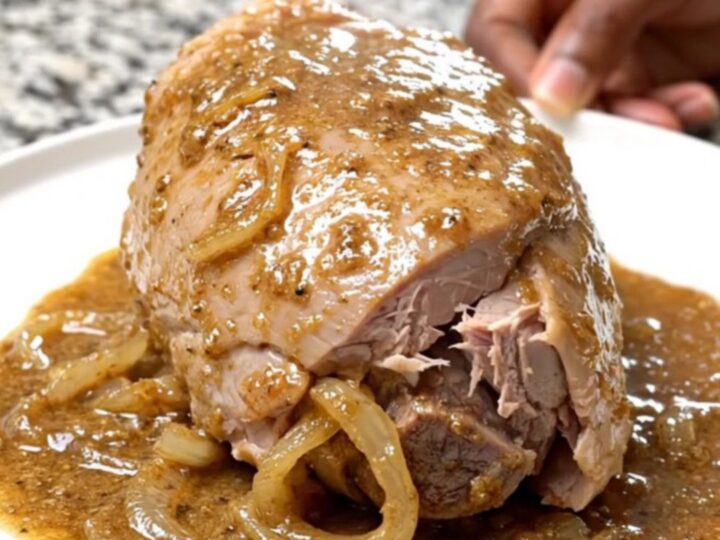 Creamy peppercorn turkey tenderloin in a slow cooker with onions and sauce.