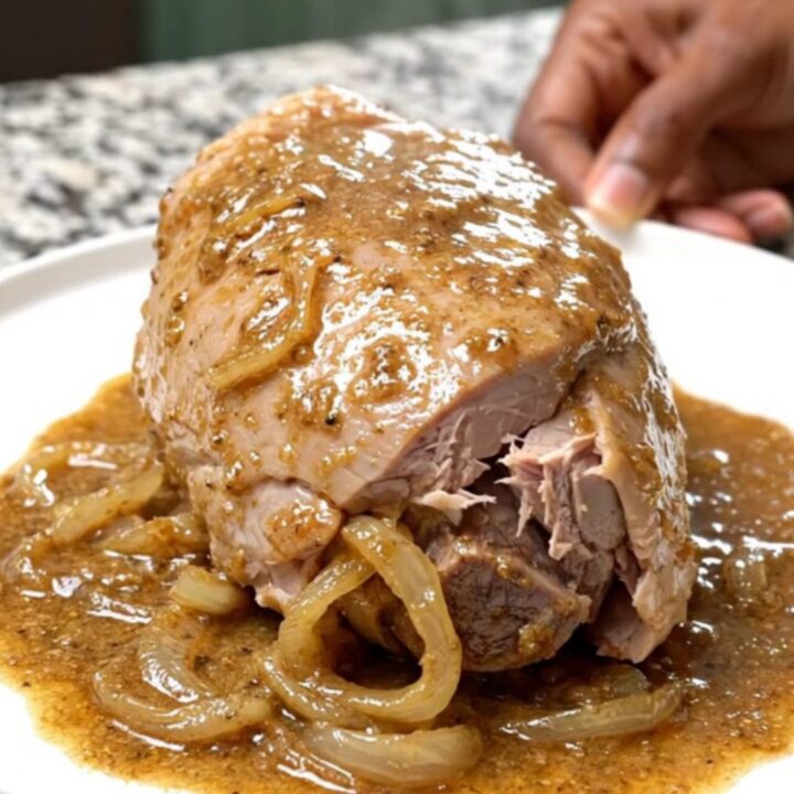 Creamy peppercorn turkey tenderloin in a slow cooker with onions and sauce.