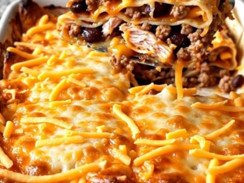 A golden, baked Mexican turkey tortilla lasagna with bubbly cheese edges in a white rectangular dish.