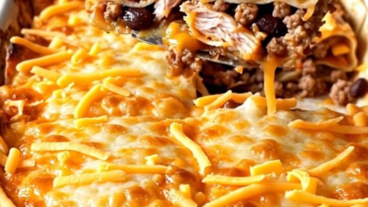 A golden, baked Mexican turkey tortilla lasagna with bubbly cheese edges in a white rectangular dish.