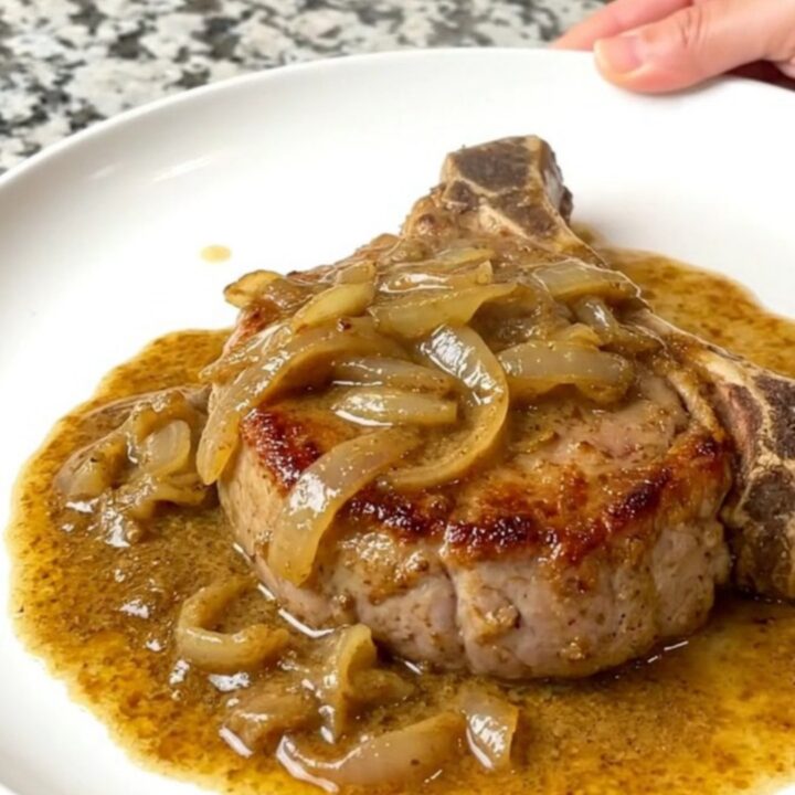 A plate of creamy smoked chile pork chops served with a rich sauce.