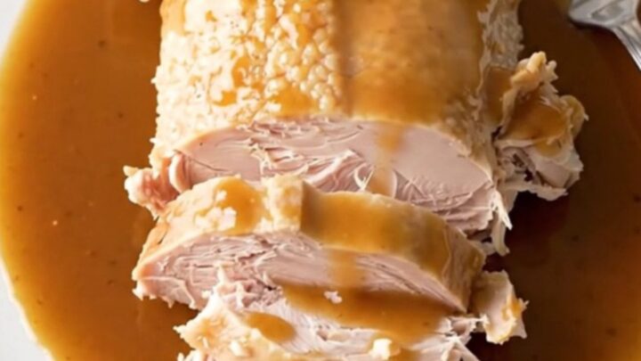 A slow cooker filled with a cooked turkey breast, sweet potato chunks, and a rich maple bourbon sauce.