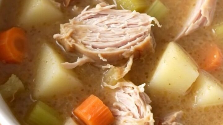 A warm bowl of creamy turkey and gravy potato soup with visible chunks of turkey and vegetables.
