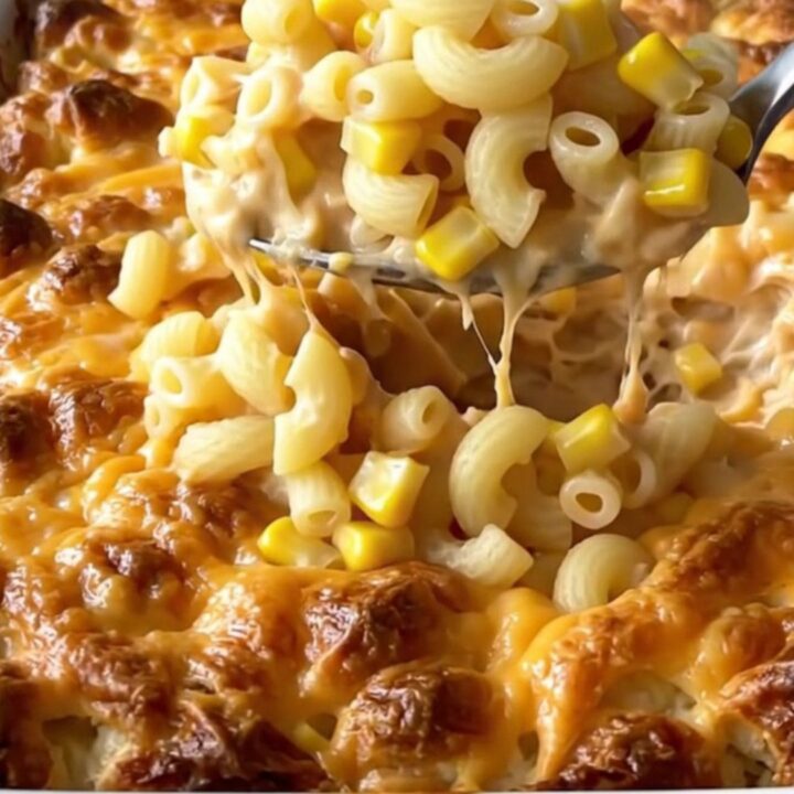 A top-down view of a rectangular baking dish filled with creamy macaroni and cheese topped with crumbled white cheese.