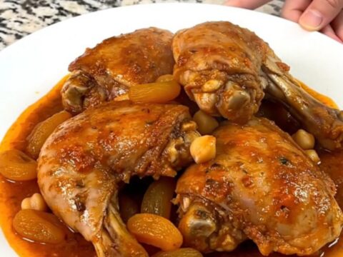 A close-up of slow-cooked Moroccan apricot chicken with chickpeas in a rich tomato sauce.