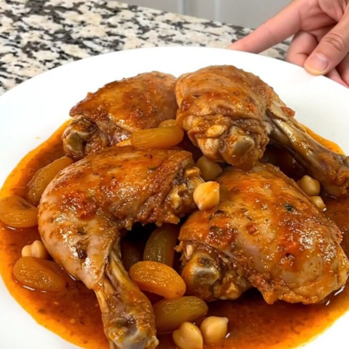 A close-up of slow-cooked Moroccan apricot chicken with chickpeas in a rich tomato sauce.