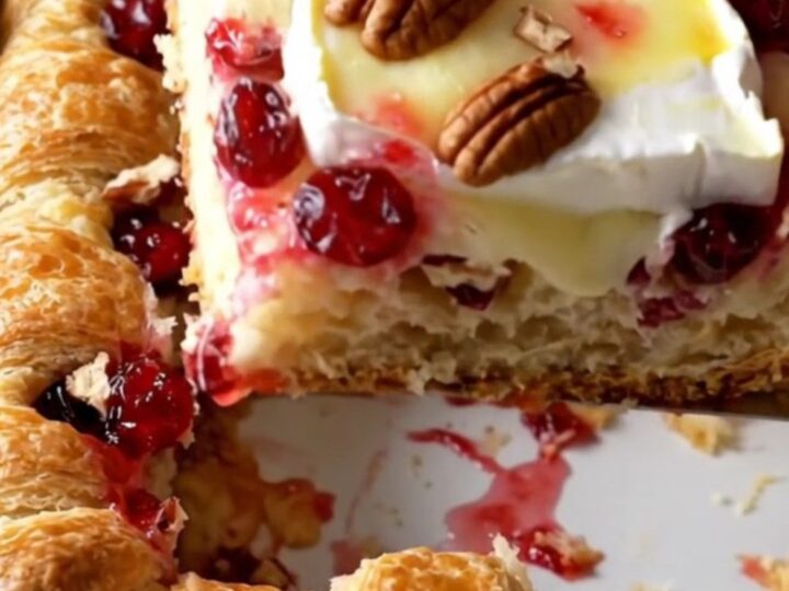 A rectangular baker filled with a golden, flaky cranberry brie crescent bake on a beige countertop.