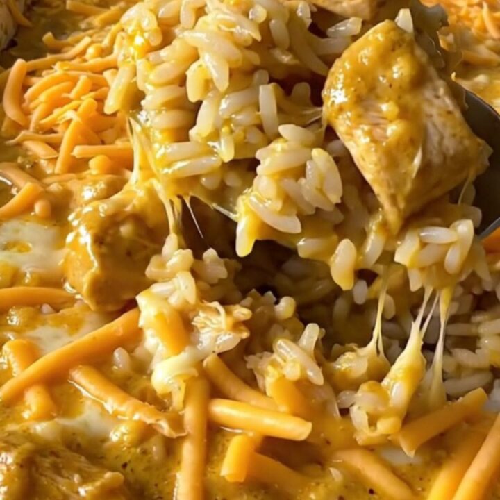 A top-down view of a rectangular baking dish filled with rice, broccoli, and creamy chicken, ready to be baked.