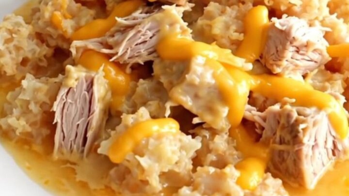 A close-up of a serving of cheesy ground turkey and hash brown casserole in a white bowl, showing creamy texture.
