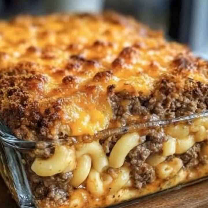 A close-up shot of a mac and cheese meatloaf casserole with a crispy golden crust and steaming layers.