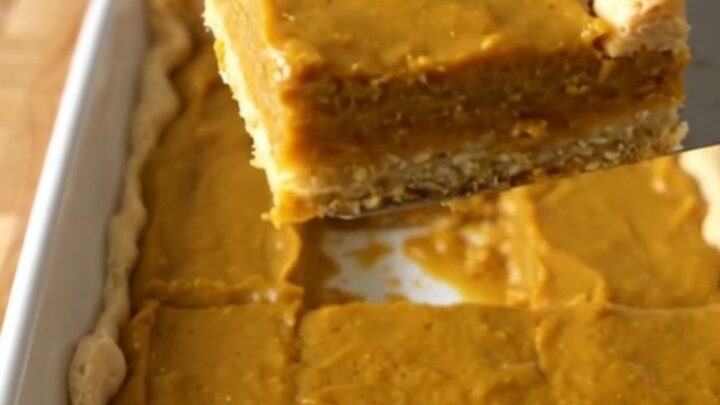 A top-down view of perfectly baked pumpkin pie crescent bars in a rectangular white baking dish.
