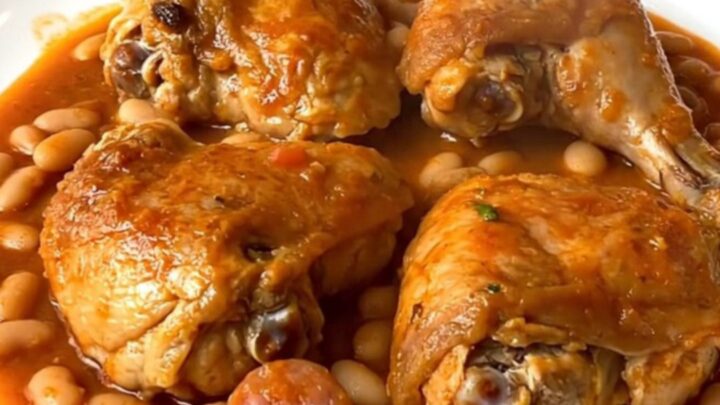 Slow cooker chicken cassoulet with sausage and beans in a black ceramic insert.