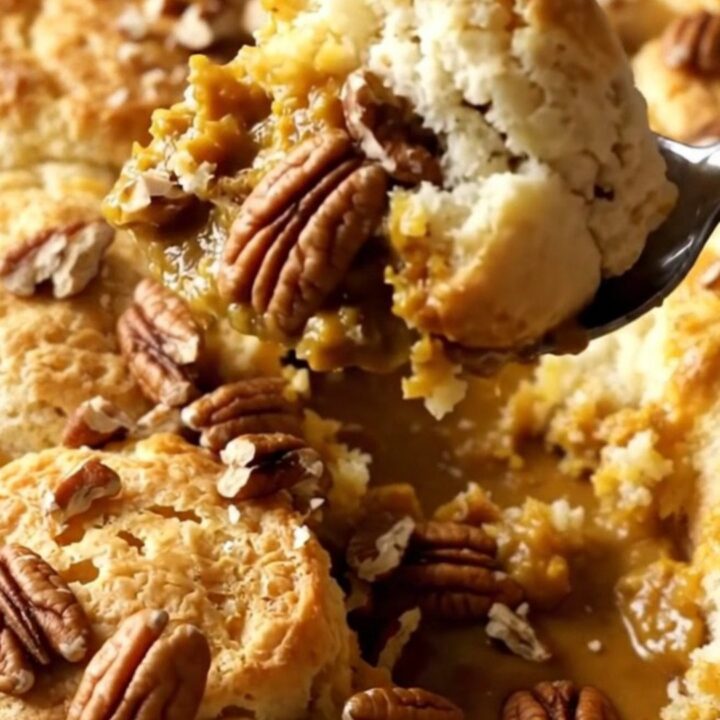 A warm pumpkin spice biscuit bubble bake in a ceramic dish, topped with crunchy pecans and golden-brown biscuits.