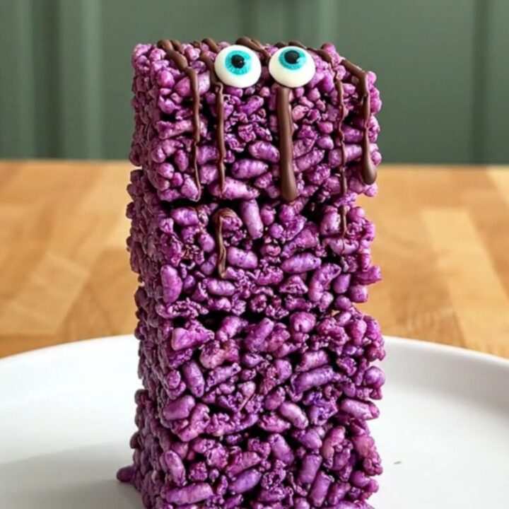 A top-down view of purple crispy rice squares on a parchment-lined baking sheet