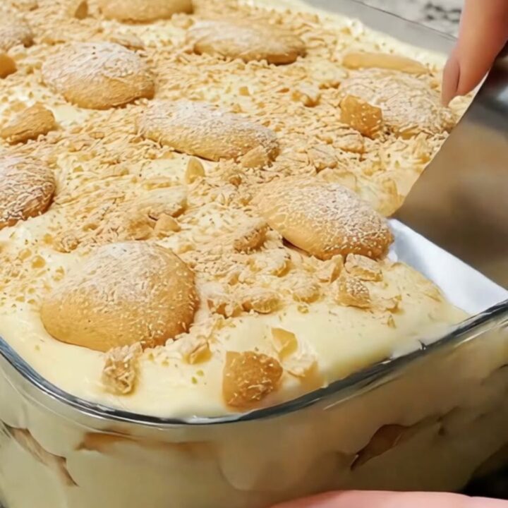 A glass baking dish filled with layers of creamy vanilla pudding, sliced bananas, and vanilla wafers.