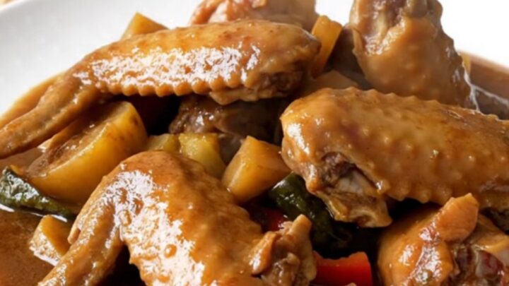A close-up of tender Jamaican brown stew turkey wings served in a rich dark gravy.