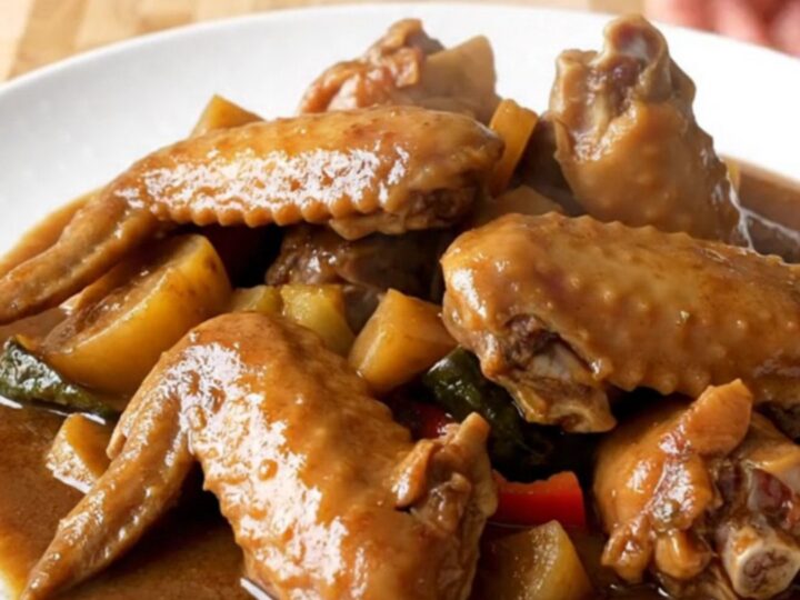 A close-up of tender Jamaican brown stew turkey wings served in a rich dark gravy.