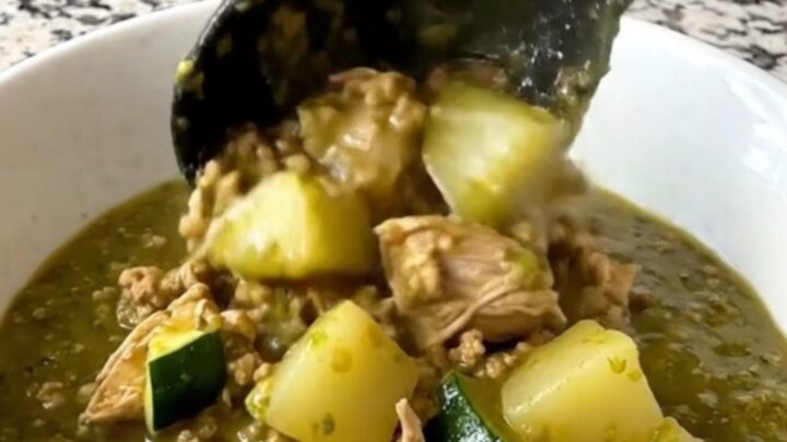 A hearty bowl of slow cooker swamp stew featuring ground turkey, zucchini, and potatoes in a vibrant green salsa verde sauce.