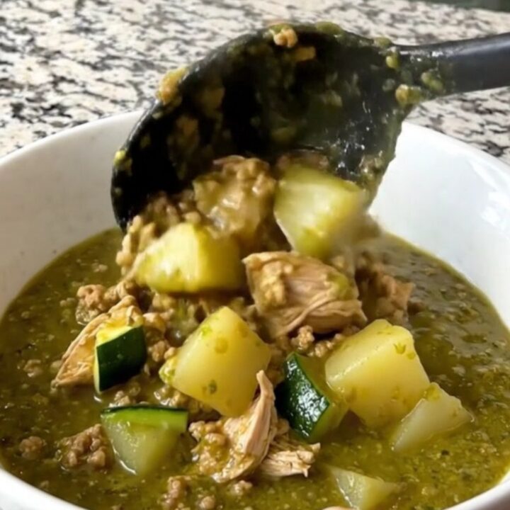 A hearty bowl of slow cooker swamp stew featuring ground turkey, zucchini, and potatoes in a vibrant green salsa verde sauce.