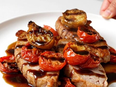 A close-up of slow-cooked turkey tenderloins topped with a balsamic tomato sauce on a white plate.