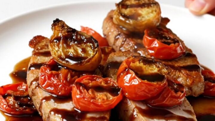 A close-up of slow-cooked turkey tenderloins topped with a balsamic tomato sauce on a white plate.