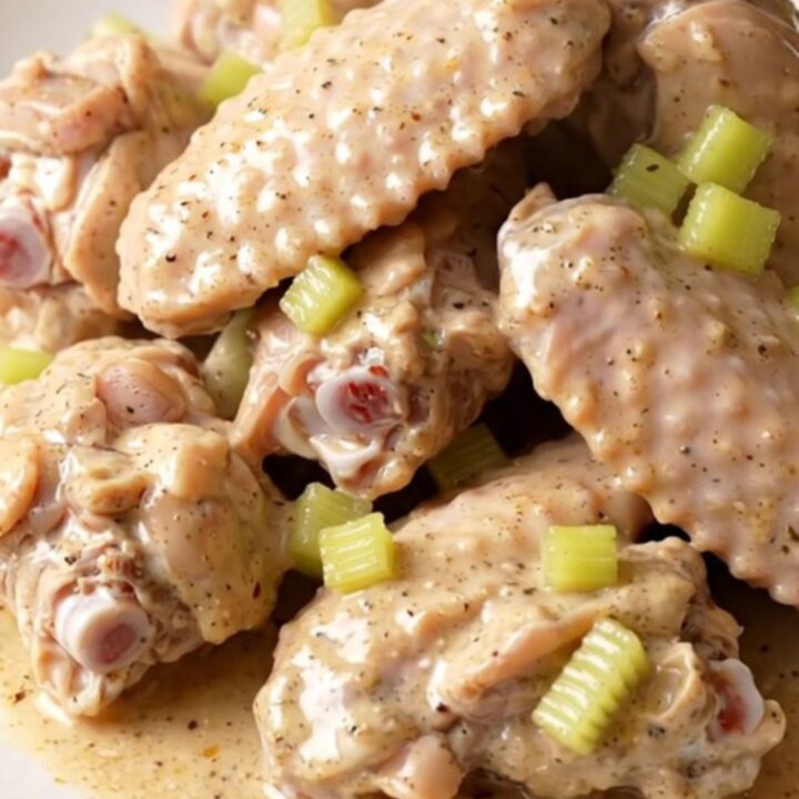 A close-up view of creamy, slow-cooked turkey wings with Cajun sauce in a slow cooker.