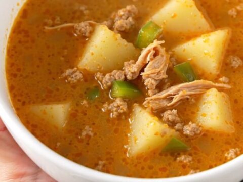 A rustic bowl of creamy Cajun ground turkey and potato soup with visible chunks of potato and turkey, steaming slightly.