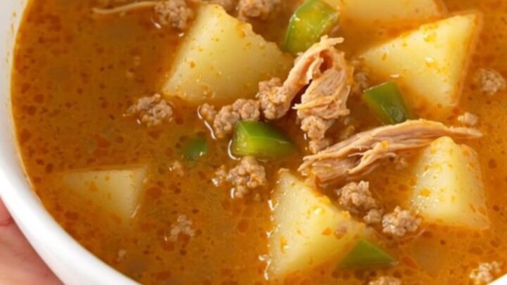 A rustic bowl of creamy Cajun ground turkey and potato soup with visible chunks of potato and turkey, steaming slightly.