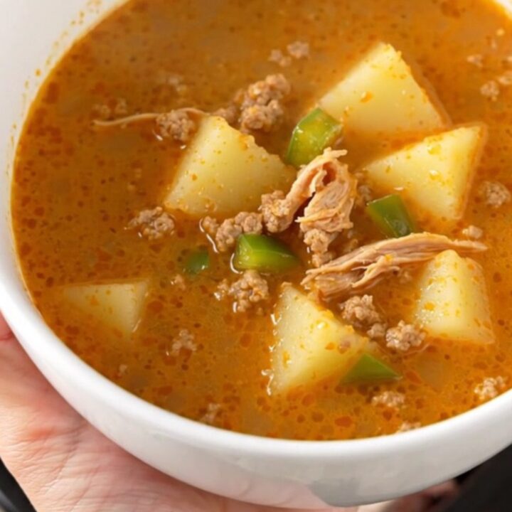 A rustic bowl of creamy Cajun ground turkey and potato soup with visible chunks of potato and turkey, steaming slightly.