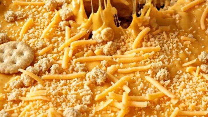 A top-down view of a rectangular baking dish filled with broccoli covered in creamy cheddar sauce and a cracker crust.