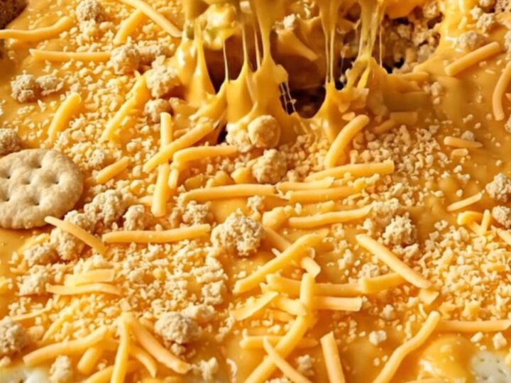 A top-down view of a rectangular baking dish filled with broccoli covered in creamy cheddar sauce and a cracker crust.